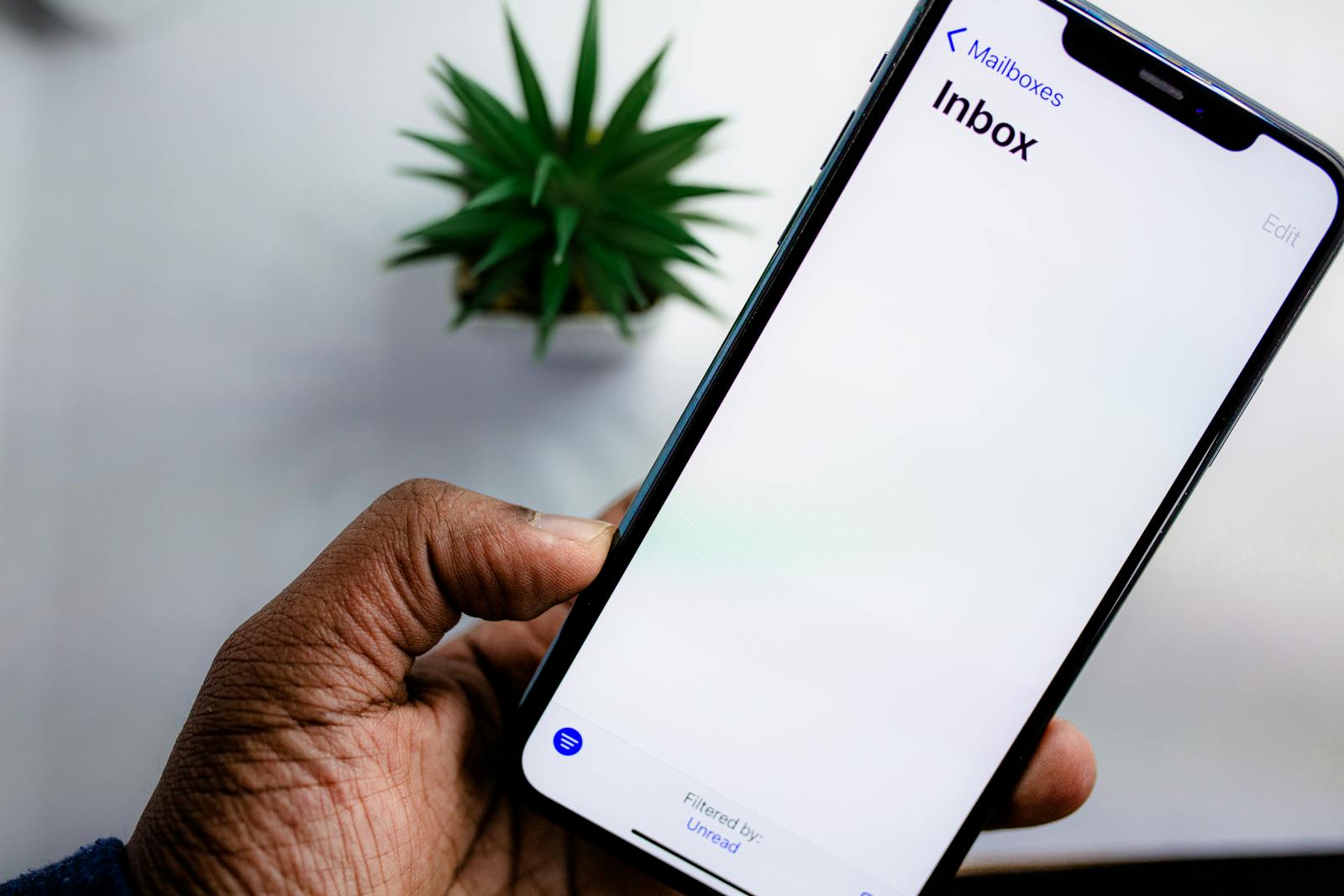 iPhone in hand showing the iOS Mail inbox screen — photo by Solen Feyissa on Pexels
