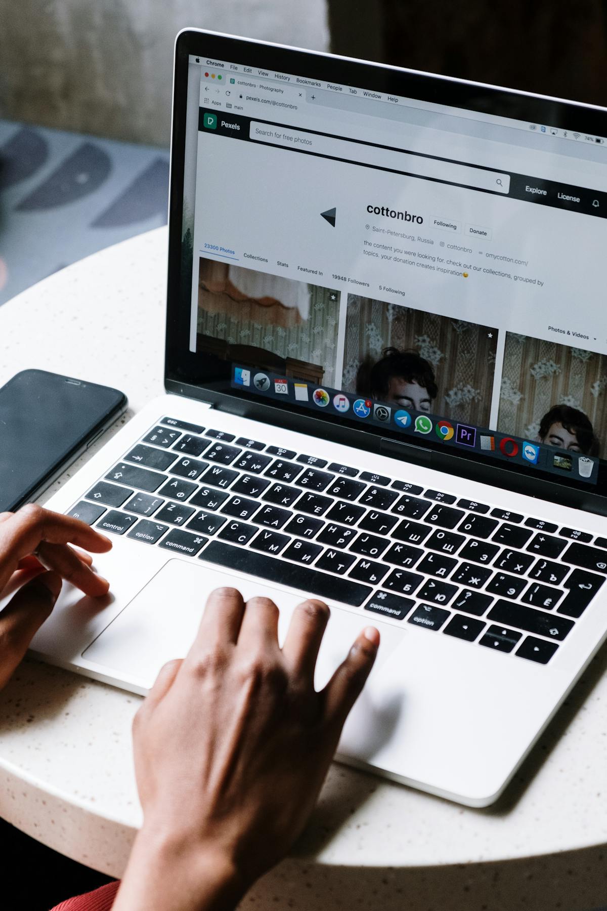 Hands typing on a MacBook displaying a web browser — typical macOS development context (photo: Cottonbro / Pexels)