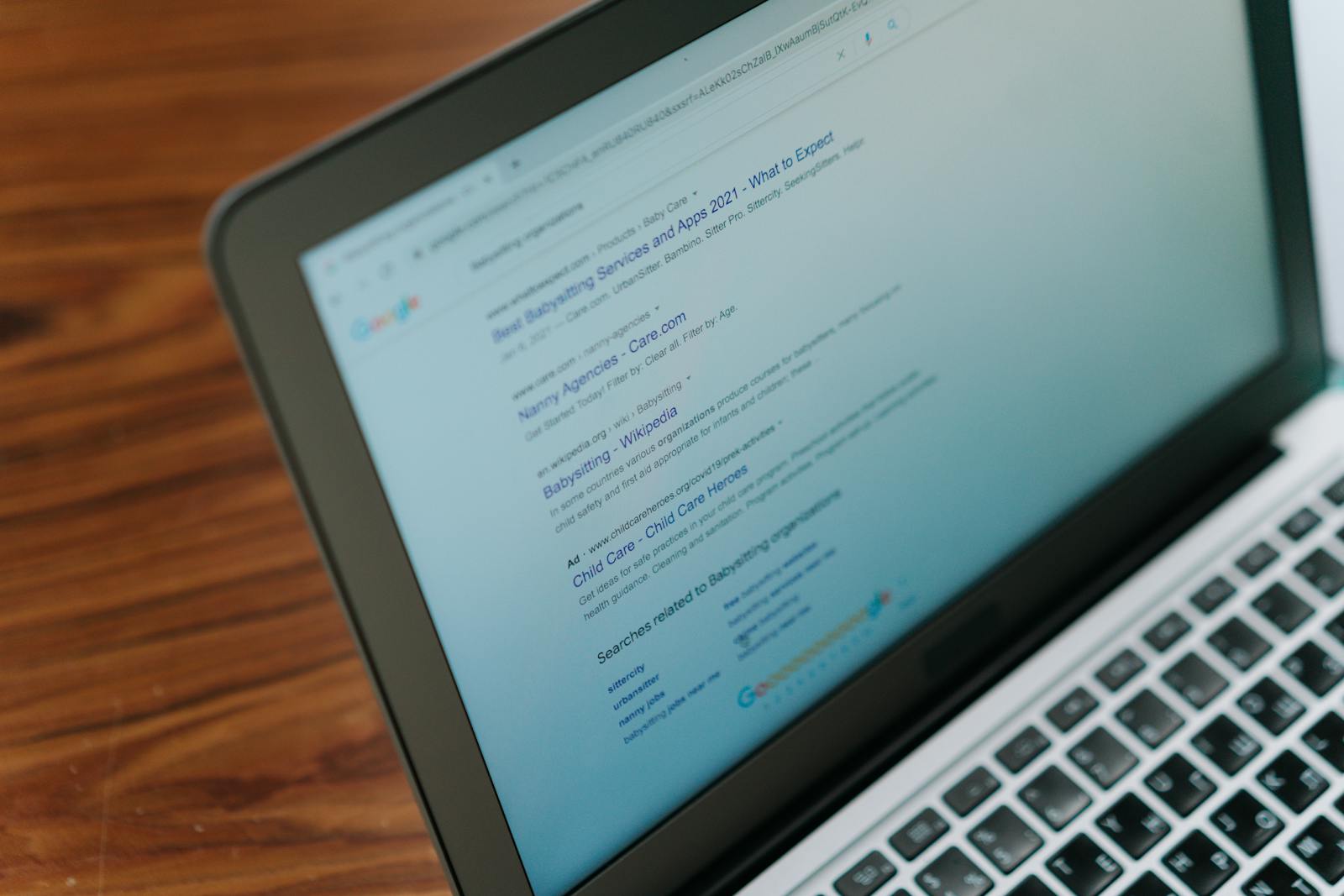 Laptop screen displaying a search results page on a wooden desk — photo by cottonbro on Pexels