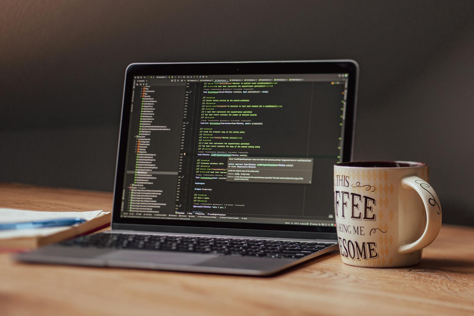 MacBook with code editor open beside a coffee mug on a wooden desk — photo by dkomov on Pexels