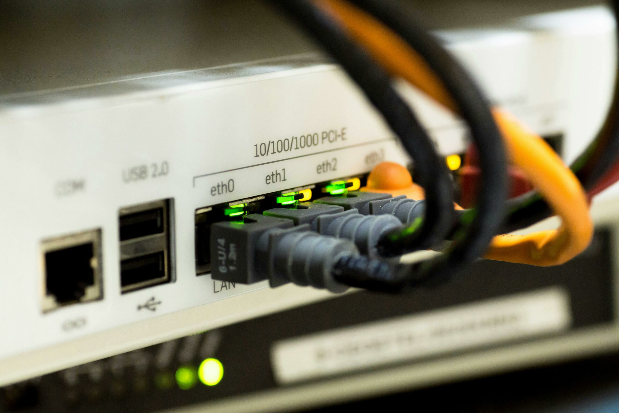 Network switch with active port LEDs and ethernet cables — photo by Pixabay on Pexels