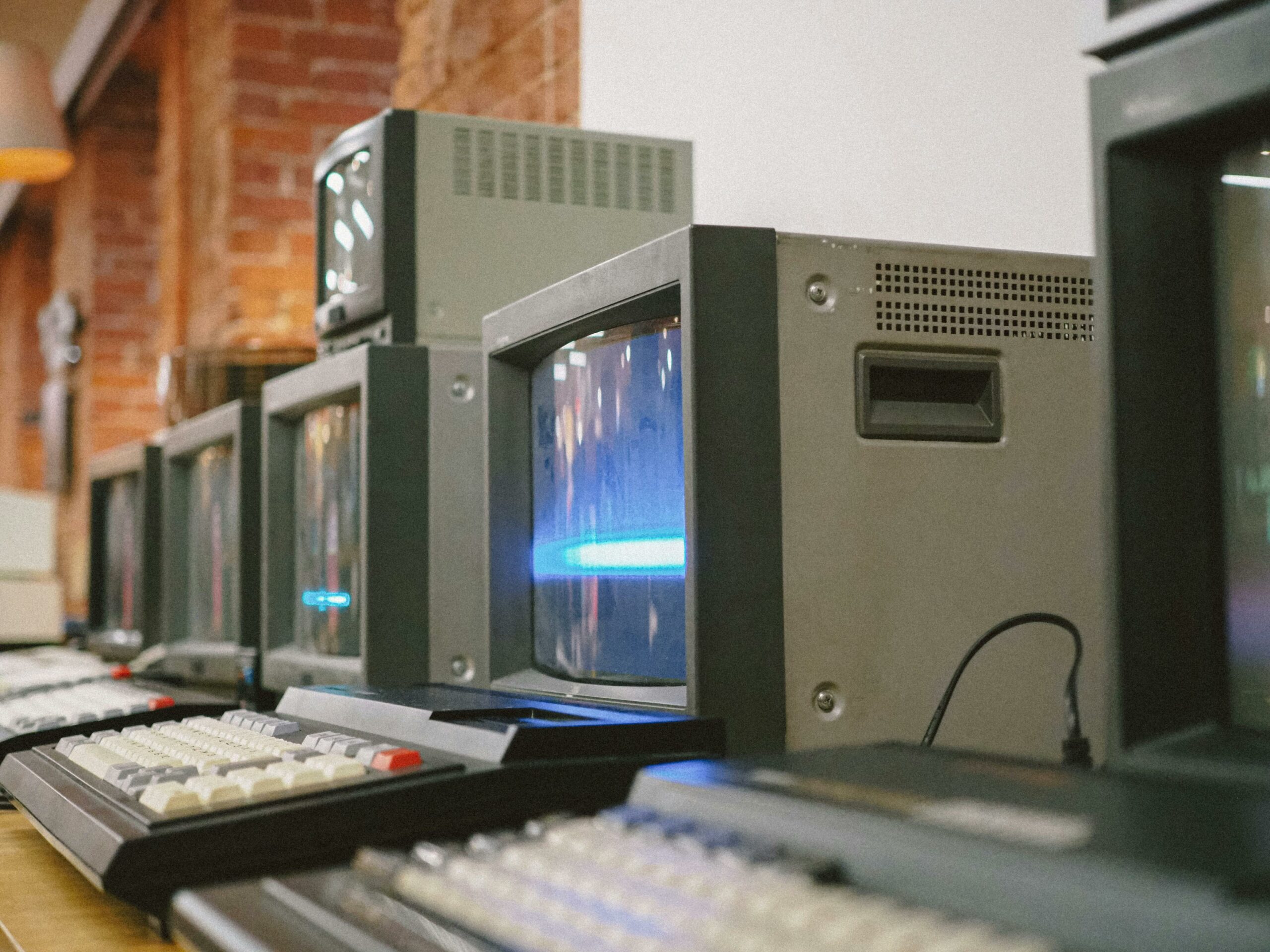 Row of vintage CRT computer monitors and keyboards — photo by John Detochka on Pexels
