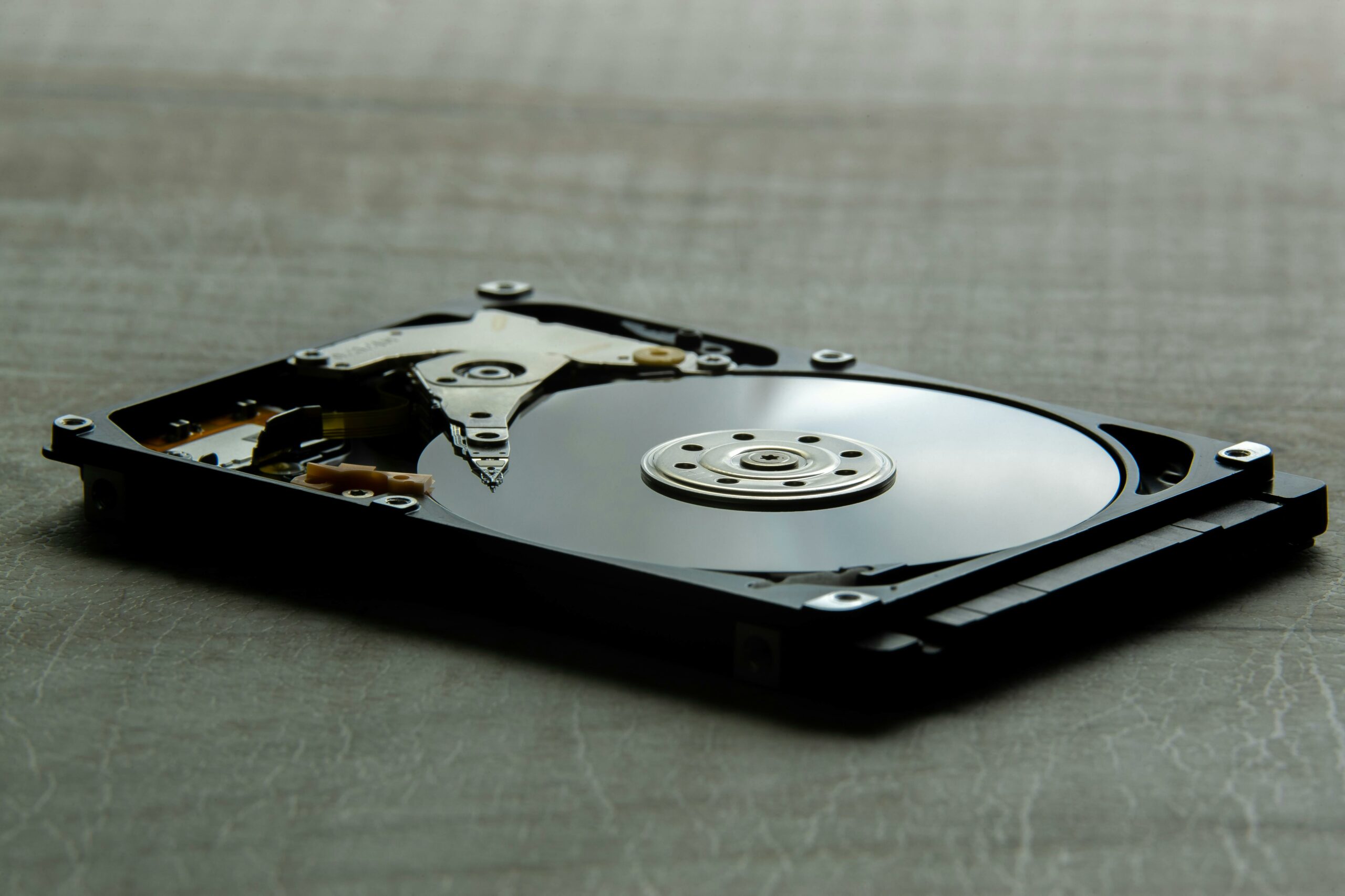 Open hard drive showing the platter and read-write head — photo by sejio402 on Pexels
