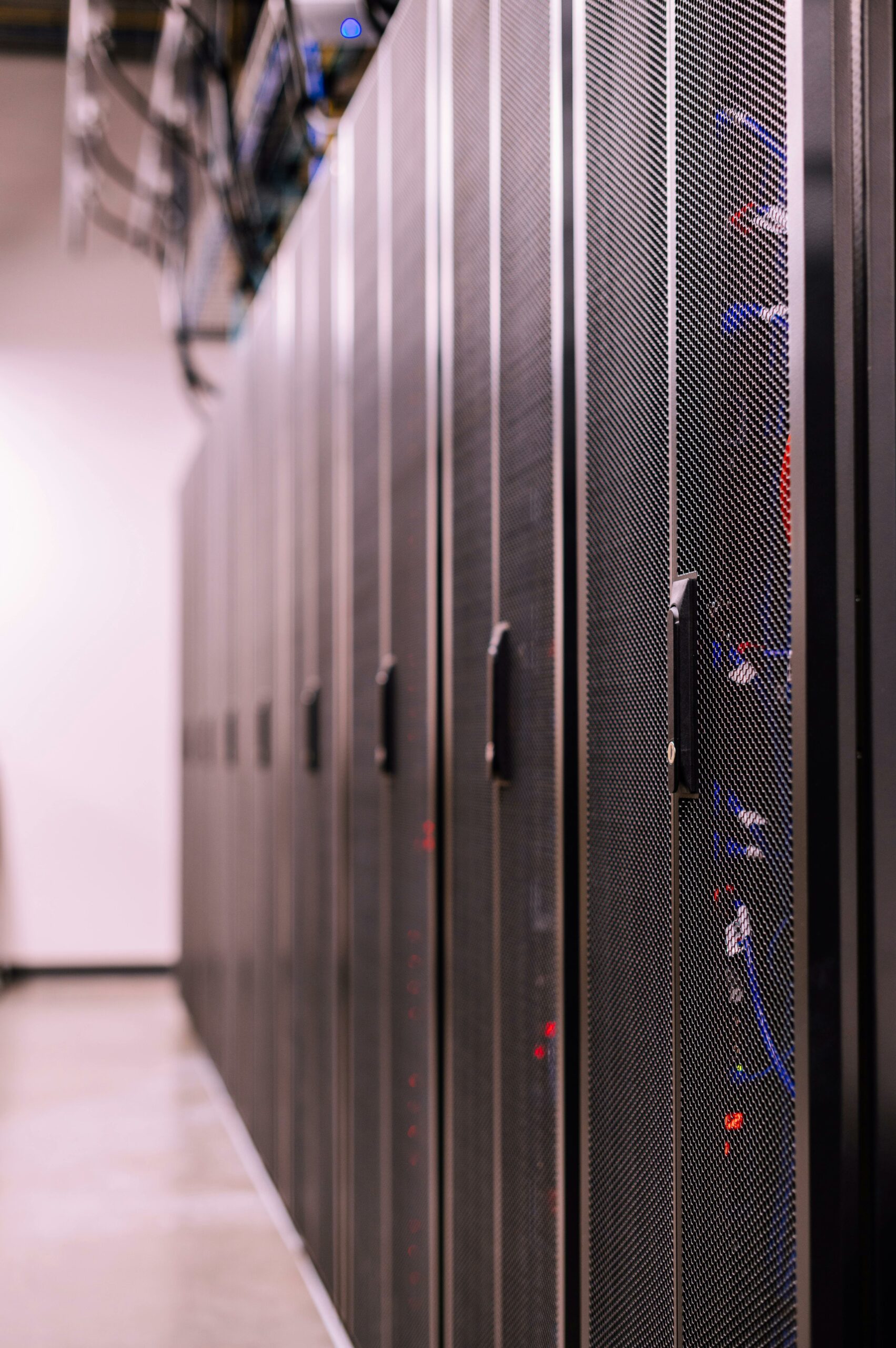 Server room aisle with rows of dark server racks — photo by Brett Sayles on Pexels