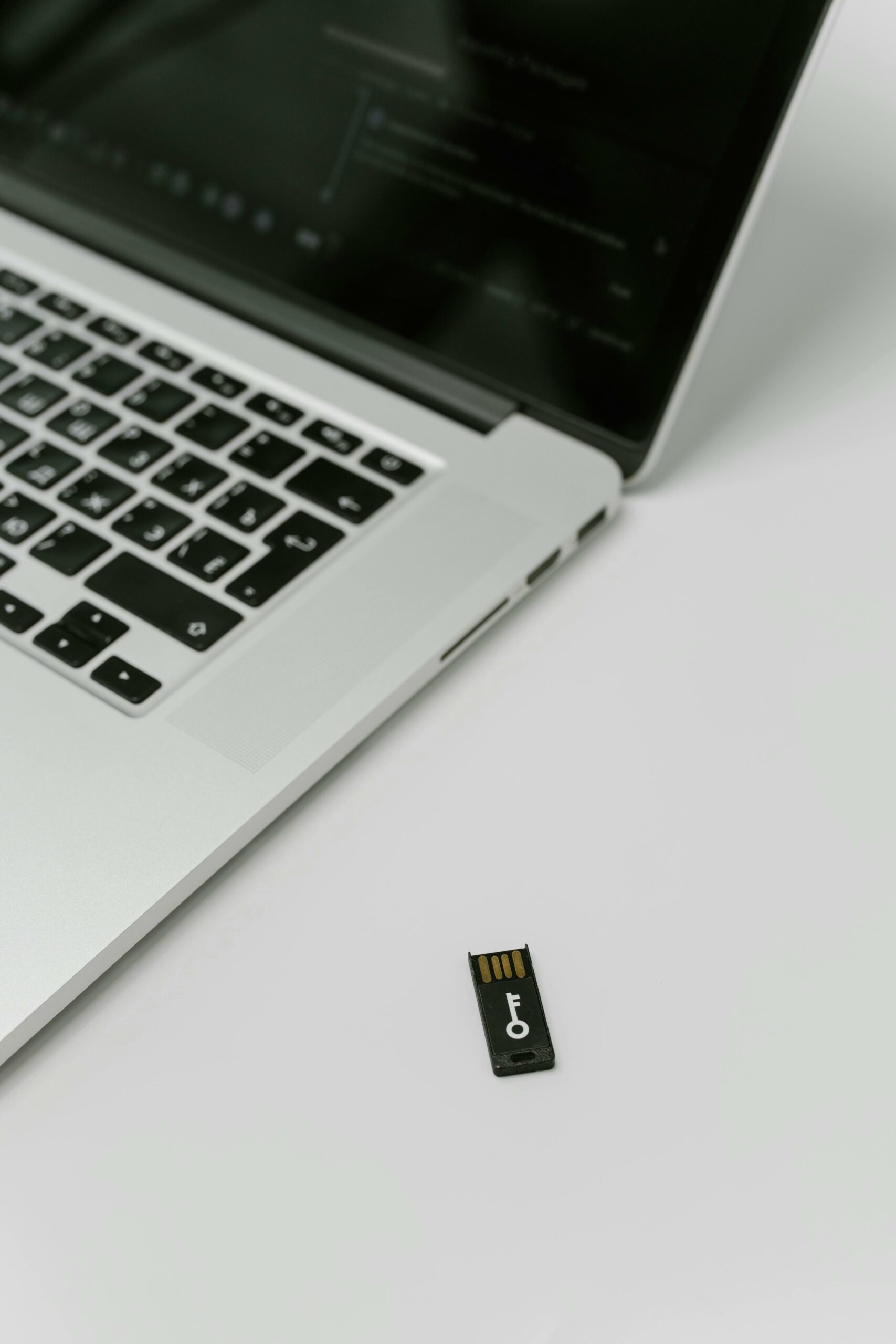 USB security key beside a laptop on a clean desk — photo by Cottonbro on Pexels