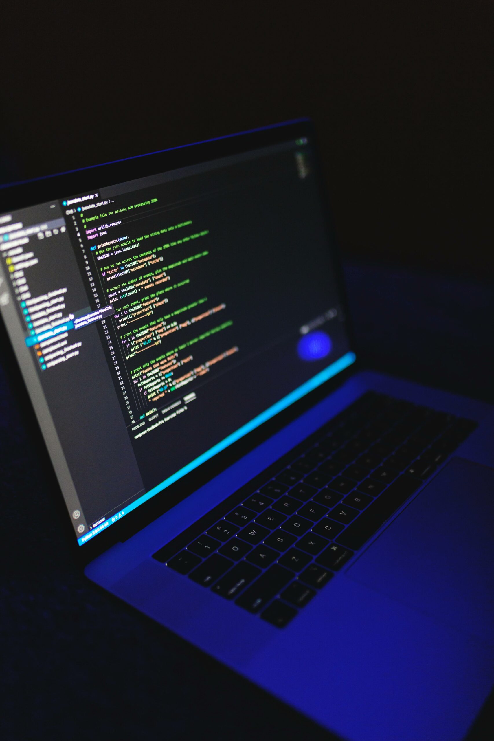 Laptop screen showing source code in low-light blue ambient — photo by Nemuel on Pexels