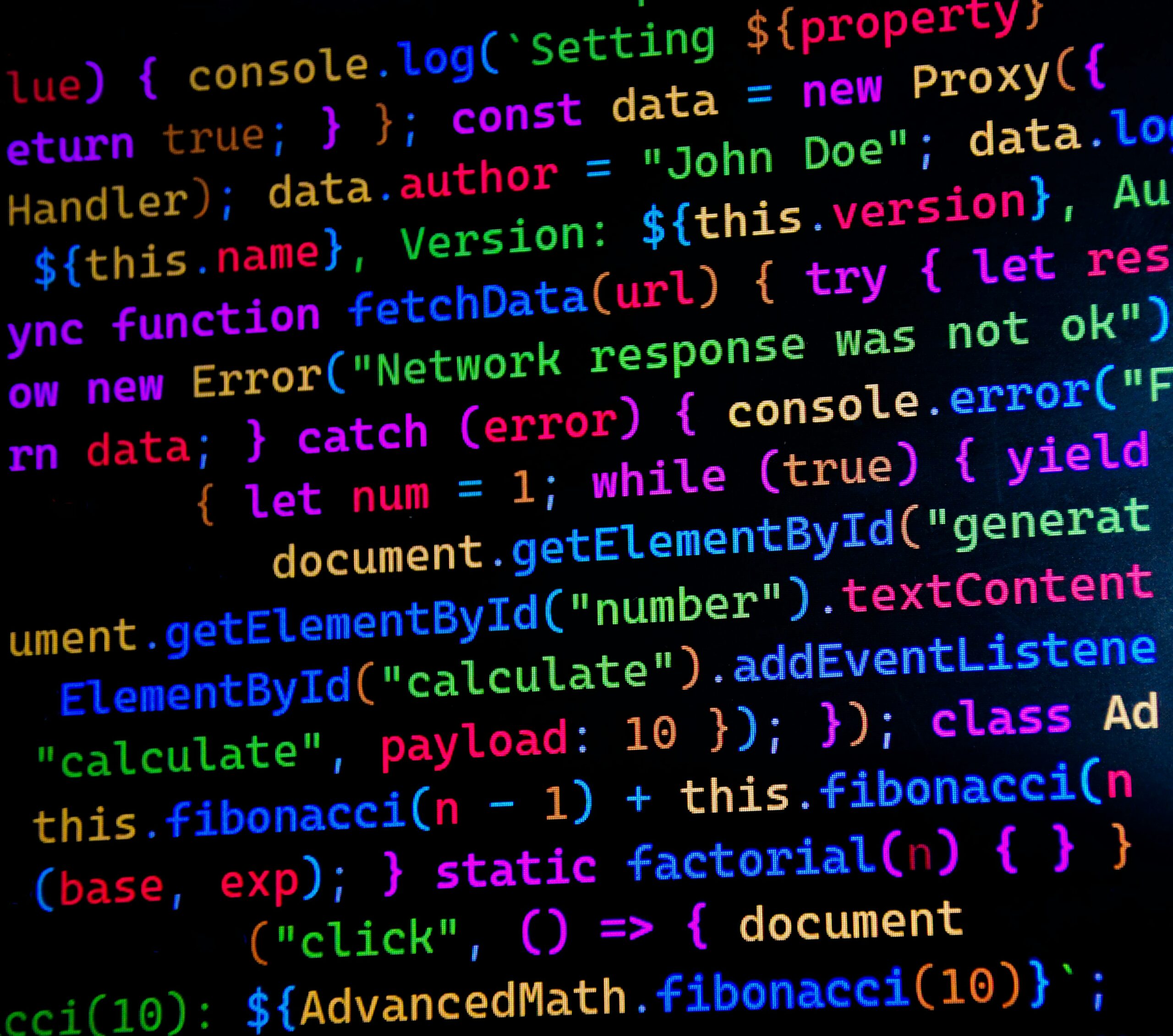 Close-up of colourful JavaScript source code on a dark monitor — photo by Peaky on Pexels
